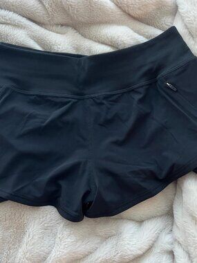 Aritzia Golden black workout shorts with tags still attached.